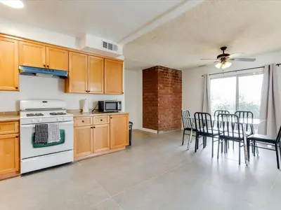 a kitchen with wooden cabinets and a table with chairs at Charming 5 Bedroom Granada Hills House with Pool in Los Angeles