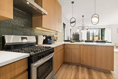 a kitchen with wooden cabinets and a stove top oven at Rooftop 3B 3BA House Near Dodger Stadium and DTLA in Los Angeles