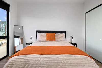 a bedroom with a large bed with an orange pillow at Rooftop 3B 3BA House Near Dodger Stadium and DTLA in Los Angeles