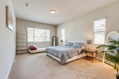 a bedroom with a bed and two windows at Beautiful Bakersfield Home about 8 Mi to Downtown! in Bakersfield