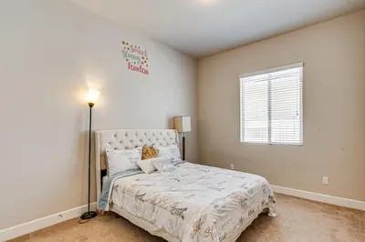 a bedroom with a bed and a window at Beautiful Bakersfield Home about 8 Mi to Downtown! in Bakersfield