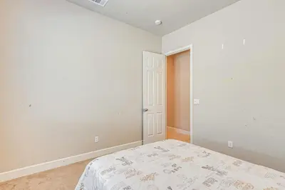 a white bedroom with a bed in a room at Beautiful Bakersfield Home about 8 Mi to Downtown! in Bakersfield