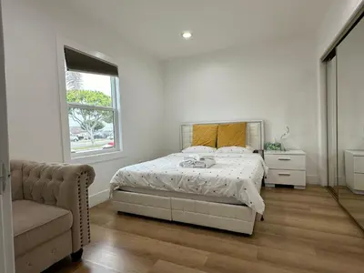 a bedroom with a bed and a chair and a window at Elegant Living Private Room in Modern Home 9 in Los Angeles