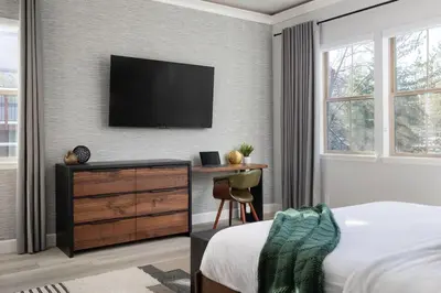 a bedroom with a bed and a television on a wall at Aspen Glen Modern Retreat in Big Bear Lake
