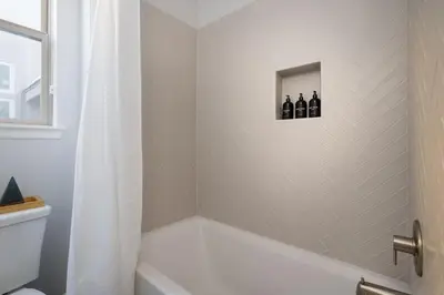 a bathroom with a tub and a shower with bottles on the wall at Aspen Glen Modern Retreat in Big Bear Lake
