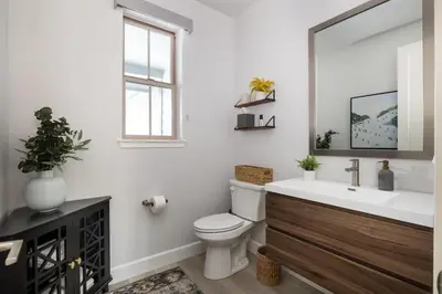 a bathroom with a toilet and a sink and a mirror at Aspen Glen Modern Retreat in Big Bear Lake