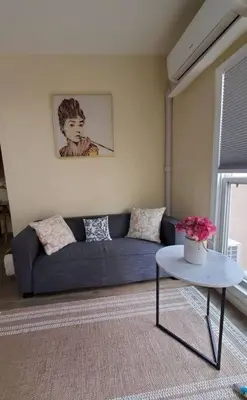 a living room with a blue couch and a table at Audrey Studio Apartment in Ktown in Los Angeles