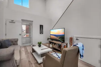 a living room with a flat screen tv on a wall at Modern 1-Bedroom Loft in Hollywood with Parking, WiFi & Hollywood Sign View in Los Angeles