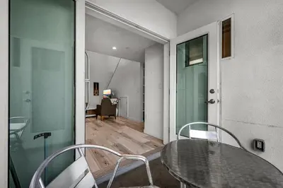 a dining room with a glass table and chairs at Modern 1-Bedroom Loft in Hollywood with Parking, WiFi & Hollywood Sign View in Los Angeles