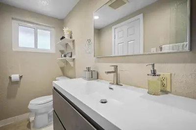 a bathroom with a sink and a toilet and a mirror at The Perfect Vacation Spot Near Six Flags Magic Mountain in Santa Clarita
