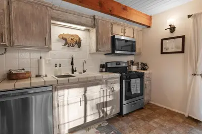 a kitchen with a sink and a stove top oven at Hillcrest HappyNest - Hot tub, fire pit, gas grill in Big Bear Lake