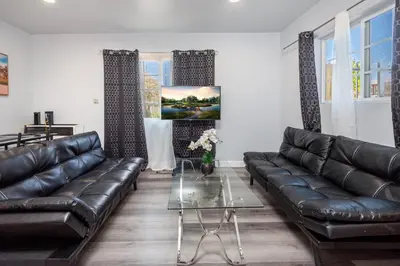 a living room with a leather couch and a table at Deluxe Modern 2BR Apt in Prime Location in Los Angeles