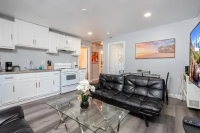 a living room with a leather couch and a glass table at Deluxe Modern 2BR Apt in Prime Location in Los Angeles
