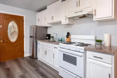 a kitchen with white cabinets and a stove at Deluxe Modern 2BR Apt in Prime Location in Los Angeles