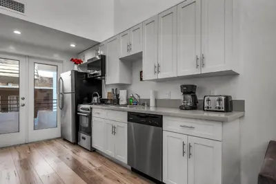 a kitchen with white cabinets and stainless steel appliances at Chic Modern Loft in Hollywood 1 Bedroom with Balcony & Free Secure Parking in Los Angeles