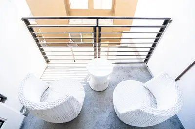 a group of white chairs on a balcony at Chic Modern Loft in Hollywood 1 Bedroom with Balcony & Free Secure Parking in Los Angeles