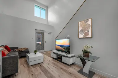 a living room with a couch and a flat screen tv at Chic Modern Loft in Hollywood 1 Bedroom with Balcony & Free Secure Parking in Los Angeles