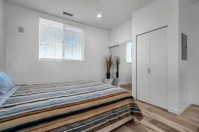 a white bedroom with a bed and two windows at Stylish Modern one Bedroom Hollywood Loft With in unite washer dryer & Balcony in Los Angeles