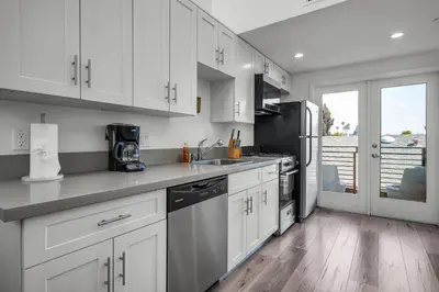 a kitchen with white cabinets and a counter top at Stylish Modern one Bedroom Hollywood Loft With in unite washer dryer & Balcony in Los Angeles