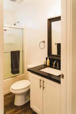 a bathroom with a toilet and a sink and a mirror at Chic Large 1 Bedroom Apartment in Koreatown with Dining Area Free Gated Parking in Los Angeles