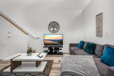 a living room with a couch and a tv at 1-Bedroom Lofts in Hollywood Modern Design, Balcony, Parking & Hollywood Sign in Los Angeles