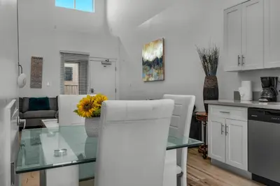 a kitchen with a glass table with a yellow flower on it at 1-Bedroom Lofts in Hollywood Modern Design, Balcony, Parking & Hollywood Sign in Los Angeles