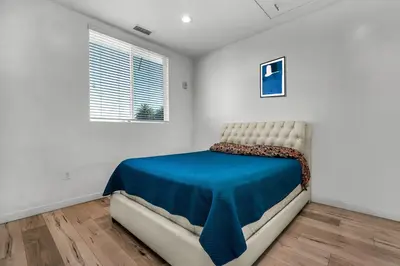 a bedroom with a bed with a blue blanket at Modern 1 Bedroom Loft in Hollywood with Full Kitchen and Central AC Free Gated Parking in Los Angeles