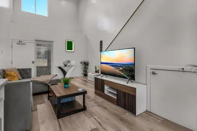 a living room with a flat screen tv on a wall at Modern 1 Bedroom Loft in Hollywood with Full Kitchen and Central AC Free Gated Parking in Los Angeles