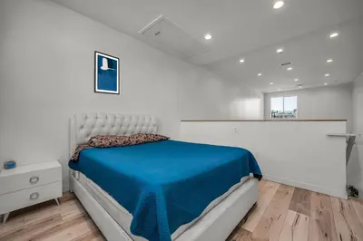 a white bedroom with a bed with a blue blanket at Modern 1 Bedroom Loft in Hollywood with Full Kitchen and Central AC Free Gated Parking in Los Angeles