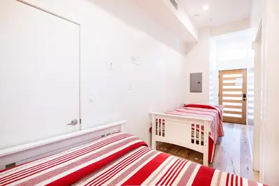 two beds in a white room with red and white stripes at Nice 2 Bedroom 3 Level Loft in Central Location Close to Downtown LA Free Gated Parking Full Kitchen in Los Angeles