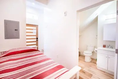 a white bedroom with a bed and a bathroom at Nice 2 Bedroom 3 Level Loft in Central Location Close to Downtown LA Free Gated Parking Full Kitchen in Los Angeles