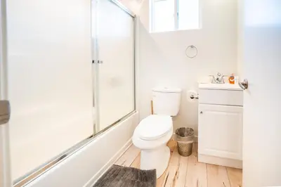 a white bathroom with a toilet and a shower at Nice 2 Bedroom 3 Level Loft in Central Location Close to Downtown LA Free Gated Parking Full Kitchen in Los Angeles