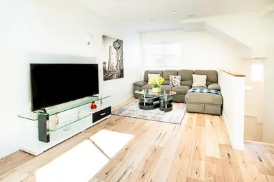 a living room with a couch and a flat screen tv at Unique 3-Level Loft with One bedroom & Two Full Bathroom in Los Angeles