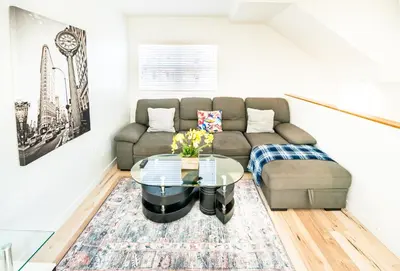 a living room with a couch and a glass table at Unique 3-Level Loft with One bedroom & Two Full Bathroom in Los Angeles