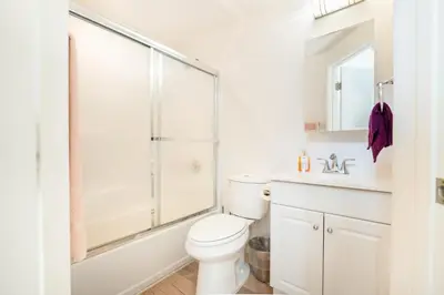 a white bathroom with a shower and a toilet at Unique 3-Level Loft with One bedroom & Two Full Bathroom in Los Angeles