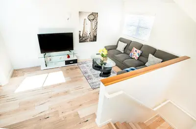 a living room with a couch and a tv at Unique 3-Level Loft with One bedroom & Two Full Bathroom in Los Angeles