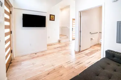 a living room with wood floors and a flat screen tv at Unique 3-Level Loft with One bedroom & Two Full Bathroom in Los Angeles