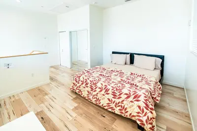 a bedroom with a bed and a wooden floor at Modern 3 Bedroom 3 Level Loft in Hollywood Sleeps 10 Free Gated Parking Full Kitchen in Los Angeles