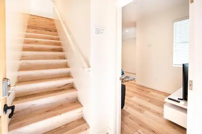 a staircase in a home with wooden floors at Modern 3 Bedroom 3 Level Loft in Hollywood Sleeps 10 Free Gated Parking Full Kitchen in Los Angeles