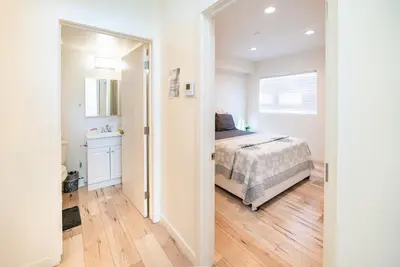 a white bedroom with a bed and a bathroom at Modern 3 Bedroom 3 Level Loft in Hollywood Sleeps 10 Free Gated Parking Full Kitchen in Los Angeles