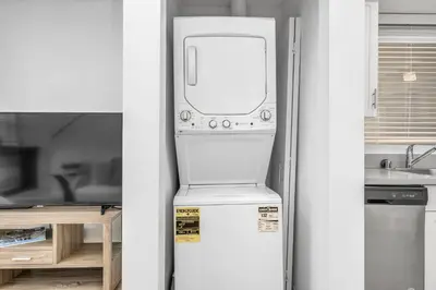 a refrigerator with a washer and dryer in a kitchen at Chic 2 Bedroom 2 Bathroom 3 Level Loft Style Condo by Hollywood Free Gated Parking Full kitchen in Los Angeles