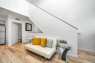 a living room with a white couch and a glass table at Chic 2 Bedroom 2 Bathroom 3 Level Loft Style Condo by Hollywood Free Gated Parking Full kitchen in Los Angeles