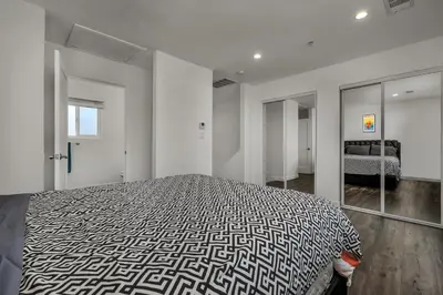 a bedroom with a large bed and a mirror at Modern 2 Levels One-Bedroom Retreat in central Location in Hollywood in Los Angeles