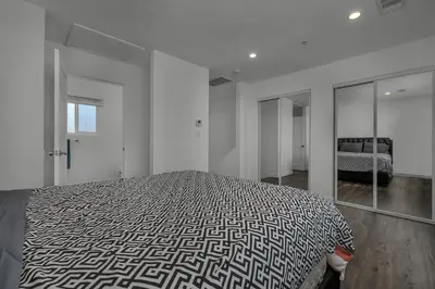 a white bedroom with a bed and a mirror at Modern 2 Levels One-Bedroom Retreat in central Location in Hollywood in Los Angeles