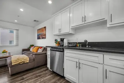 a kitchen with white cabinets and a couch at Modern 2 Levels One-Bedroom Retreat in central Location in Hollywood in Los Angeles