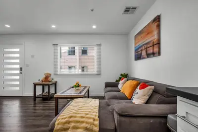a living room with a couch and a table at Modern 2 Levels One-Bedroom Retreat in central Location in Hollywood in Los Angeles