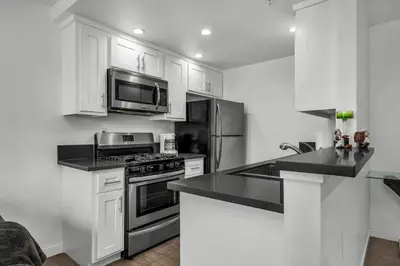 a kitchen with white cabinets and a stove and a microwave at Fully Furnished 1 Bedroom Apartment with Full Bathroom in Koreatown Free Gated Parking Full Kitchen in Los Angeles