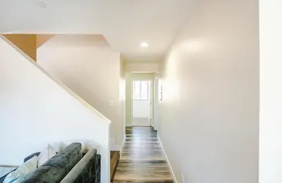 a hallway of a house with white walls and wooden floors at Spacious 5 Bedroom 3 Bath Home for Large Groups By DT LA in Los Angeles