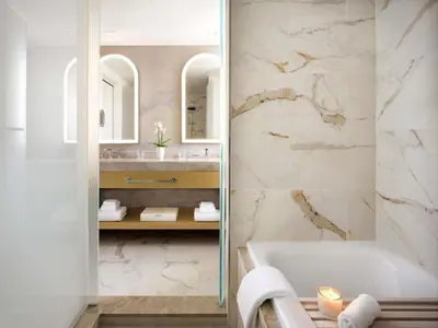 a bathroom with a tub and a sink at Fairmont Breakers Long Beach in Long Beach