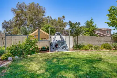a playground in a yard with a fence at Rio Bravo Country Club Home in Bakersfield with Pool in Bakersfield